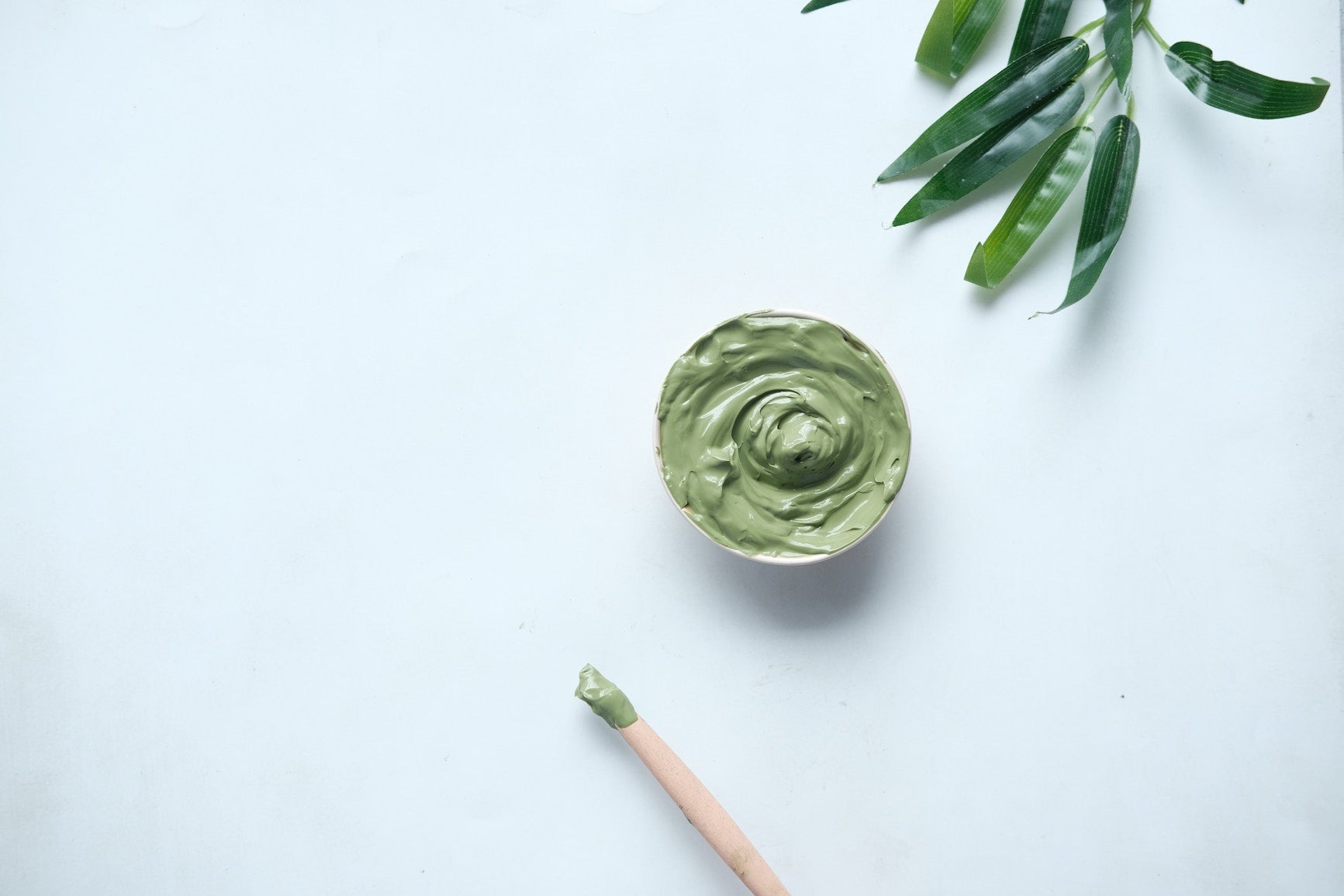 Crema hidratanta de culoarea verde cu spatula și aspect natural